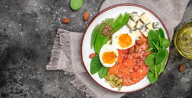 Keto diet food salmon avocado cheese egg spinach and nuts Ketogenic low carbs diet concept Ingredients for healthy foods Long banner format top view