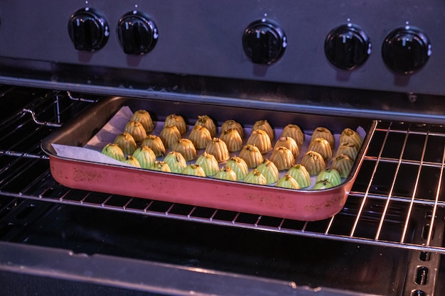 Keto eid kahk with almond dough arranged in a grill tray inside the oven