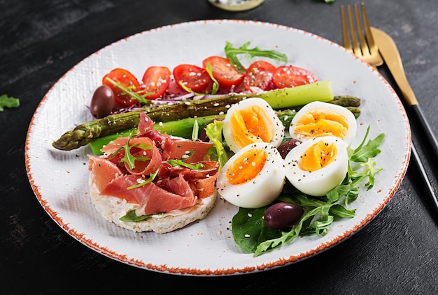 Keto-ontbijt Gebakken asperges met gekookte eieren en toast met prosciutto of jamon Ketogeen dieet Gezonde voeding