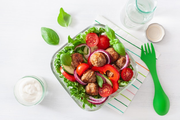 Keto paleo lunch box with meatballs, lettuce, tomato, cucumber, bell pepper