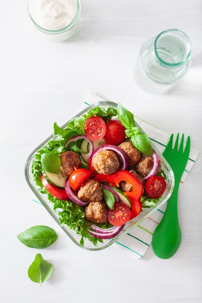 Keto paleo lunch box with meatballs, lettuce, tomato, cucumber, bell pepper