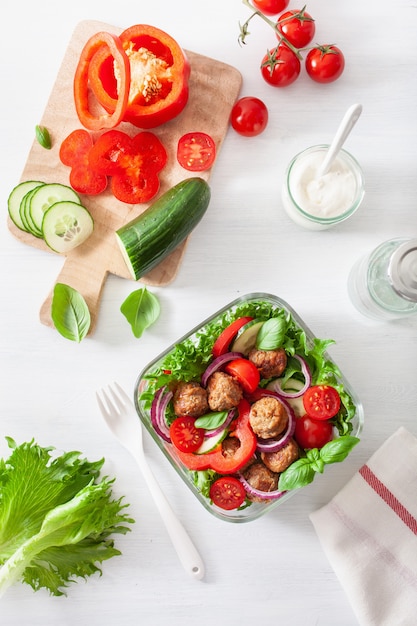 Keto paleo lunch box with meatballs, lettuce, tomato, cucumber, bell pepper