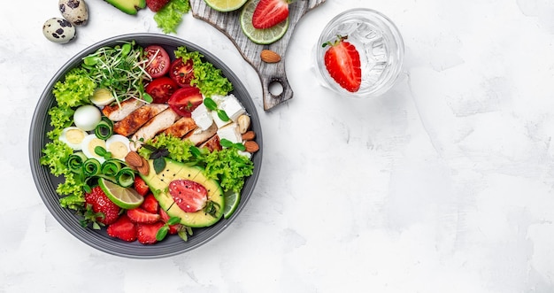 Ketogeen dieet voedsel kipfilet quinoa avocado avocado feta kaas kwarteleitjes aardbeien noten en sla gezonde maaltijd concept bovenaanzicht