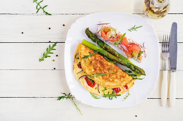 Ketogeen ontbijt omelet met tomaten rode ui sandwich met zalm en geroosterde asperges italiaanse frittata keto ketogene lunch bovenaanzicht plat liggend