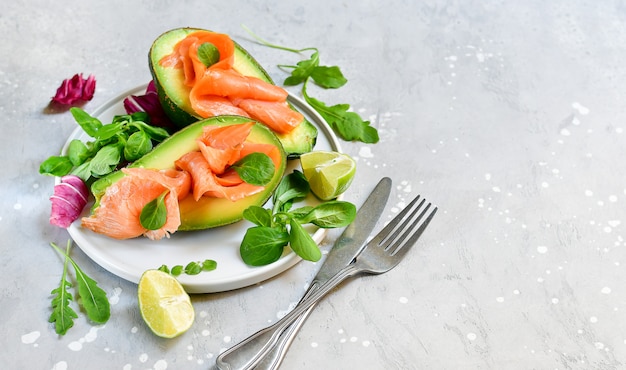 ketogenic diet food salmon and avocado salad with arugula and lime. keto food