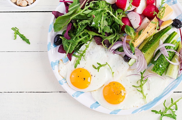 Cibo chetogenico noci al formaggio con uova fritte e insalata fresca colazione keto paleo vista dall'alto spazio per la copia dall'alto