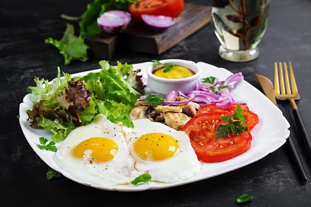 Ketogenic food Fried eggs mushrooms and sliced tomatoes Keto paleo breakfast