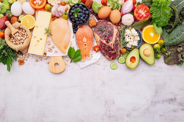 Foto concetto di dieta chetogenica a basso contenuto di carboidrati ingredienti per la selezione di cibi sani su sfondo bianco di cemento