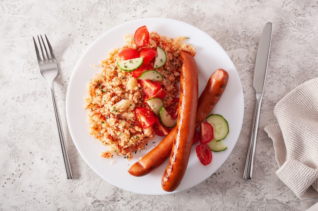 Ketogenic paleo diet lunch. cauliflower rice and grilled sausages