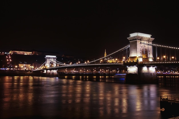 Kettingbrug over de Donau met lichtreflectie's nachts