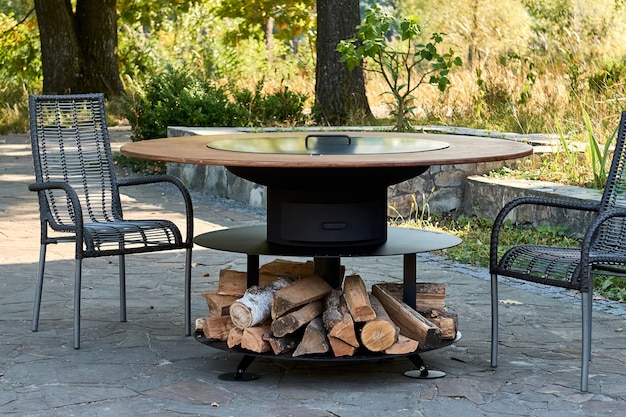 Kettle Grill Pit with Cast Iron Grid with flames . Round table-cooking surface. Hot BBQ on Backyard