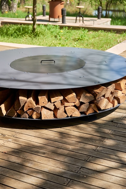 Kettle grill pit with cast iron grid with flames  round tablecooking surface hot bbq on backyard