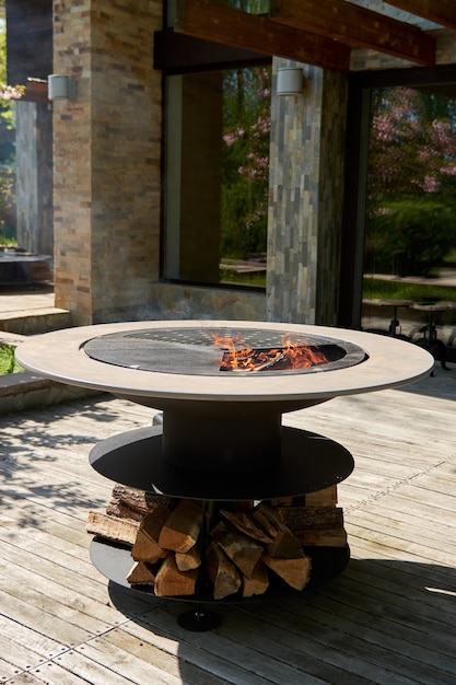 Kettle grill pit with cast iron grid with flames  round tablecooking surface hot bbq on backyard