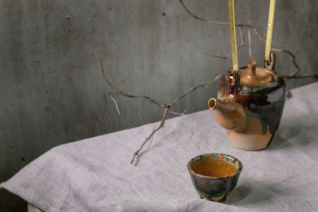 Photo kettle with cup of hot green tea