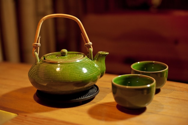 A kettle with two cups on the table