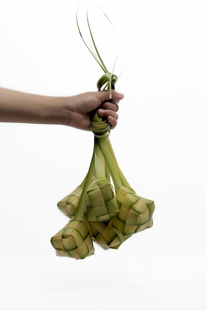 사진 색 배경에 고립 된 손에 ketupat 가방