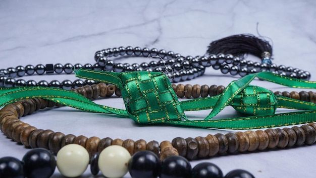 白い大理石のテーブル ラマダン背景コンセプトに Tasbih ロザリオ ビーズと Ketupat ライス キューブ