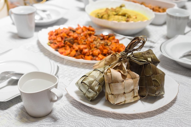 Ketupat servito con vari cibi indonesiani speciali. menu tradizionale indonesiano durante eid mubarak