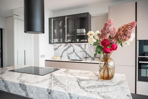 Keuken in nieuw luxe huis met granieten kwartstafel met boeket bloemen