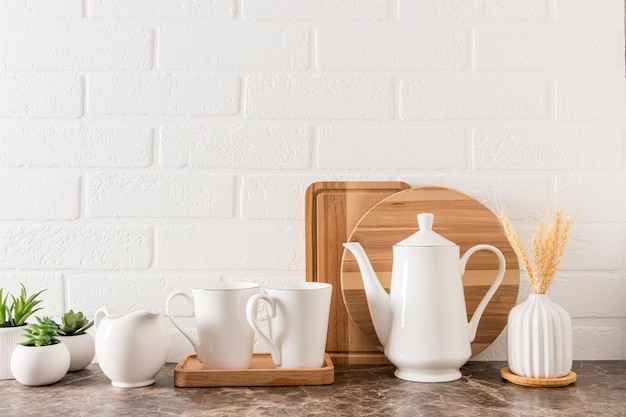 Keuken moderne achtergrond wit porselein koffiepot kopjes melkboer binnen bloemen in potten vooraanzicht