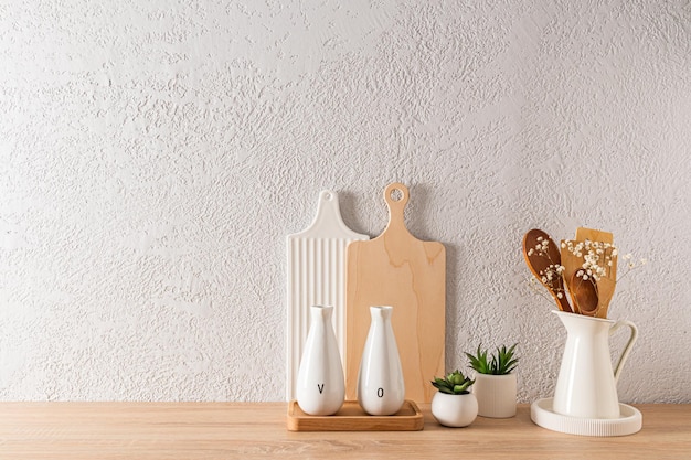 Keukenachtergrond in minimalistische vorm met een set snijplanken en flessen olie houten tafelblad grijze betonnen wand een kopieerruimte