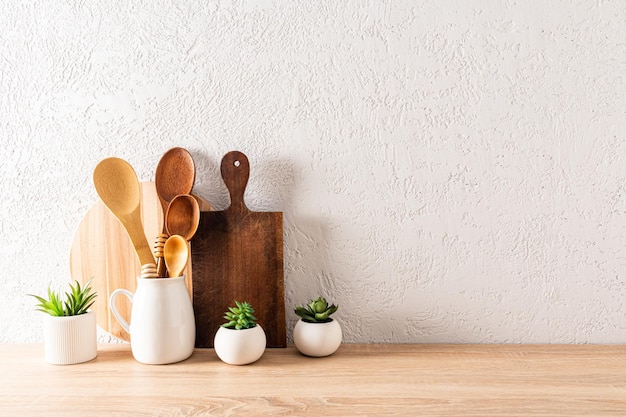 Keukenachtergrond voor de lay-out met snijplanken, houten lepels in de kan en ingemaakte kamerplanten minimalisme een kopie