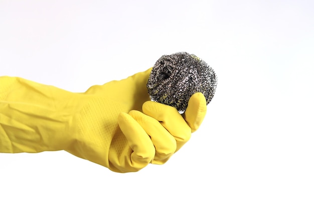 Foto keukenborstel van roestvrij staal barbecue reinigingsgereedschap een hand in een gele latex handschoen