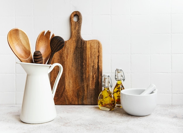 Keukengerei, gereedschap en servies op de witte tegelmuur als achtergrond. Interieur, moderne keukenruimte in heldere kleuren. Lege ruimte voor een tekst, vooraanzicht