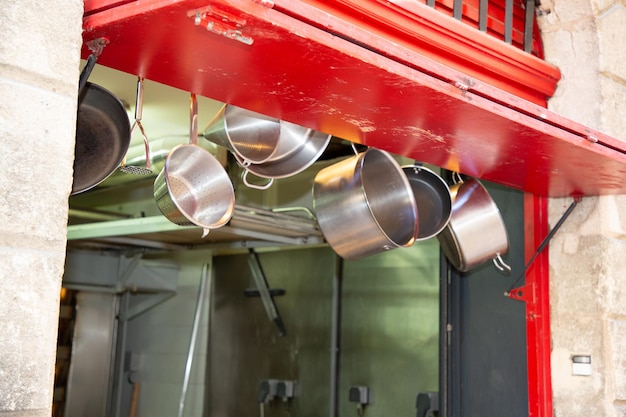 Foto keukengerei set pannen hangen in restaurant keuken roestvrijstalen kookgerei op straat om mee te nemen om te gaan