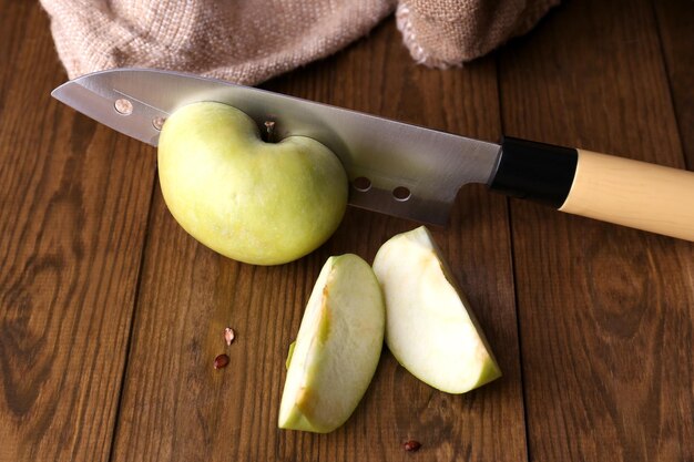 Foto keukenmes en groene appel op houten achtergrond