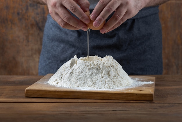 Keukentafel. Mannelijke bakker die deeg voorbereiden bij de bakkerij