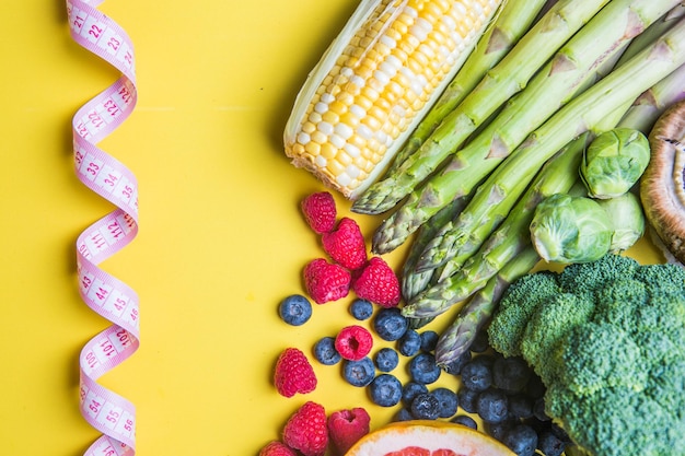 Keuze uit gezonde voeding voor hartlevensconcept op een gekleurde achtergrond met kopieerruimte bovenaanzicht Voedingsmiddelen inclusief groenten fruit gezond eten fitness
