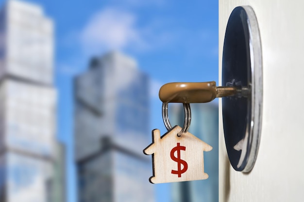 Key in the door lock of an open door on the background of urban development