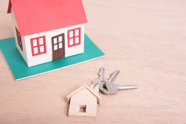 Key home and model house on wood table background.