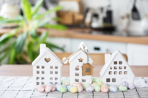 Key to house of cozy home with Easter decor with rabbit and eggs on table of kitchen Building design project moving to new house mortgage insurance rent and purchase real estate