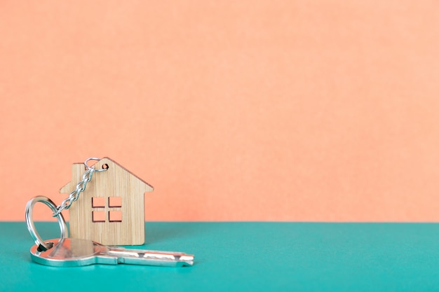 a key on a house shaped wooden keychain