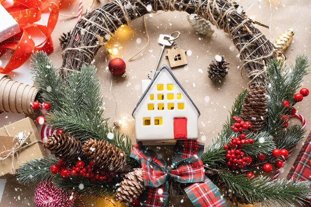 Key to the house with a keychain on a cozy home with a Christmas decor layout A gift for New Year Christmas Building design project moving to new house mortgage rent and purchase real estate