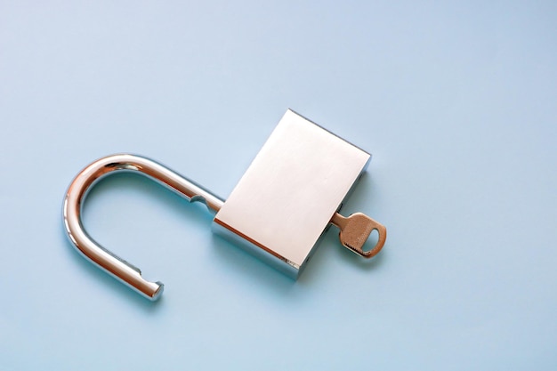 Key open padlock on blue background