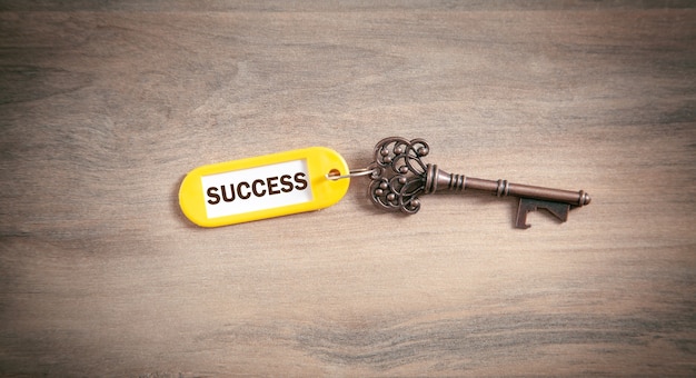 Photo key to success on the wooden background.