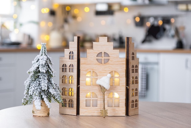 Key and tiny house of small size on cozy home with Christmas decor on table of festive white kitchen