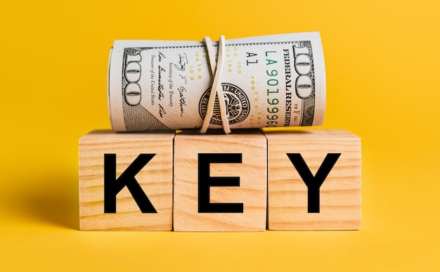 KEY with money on a yellow wall
