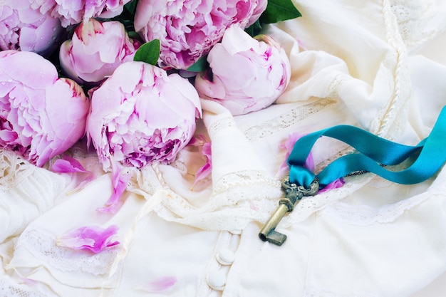 Photo key with pink peony flowers on vintage lace garment