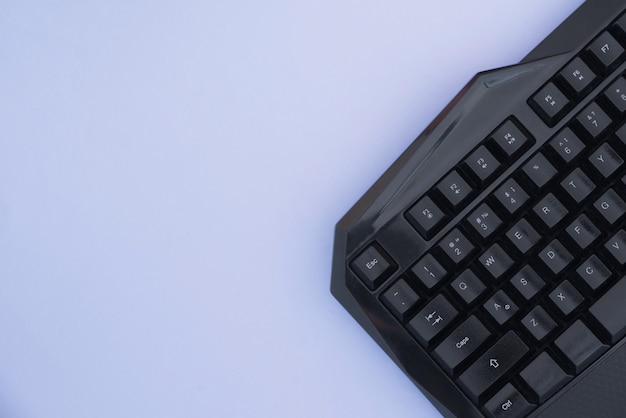 Keyboard, on a blue background, top view. Computer device, top view. Workspace flat lay.