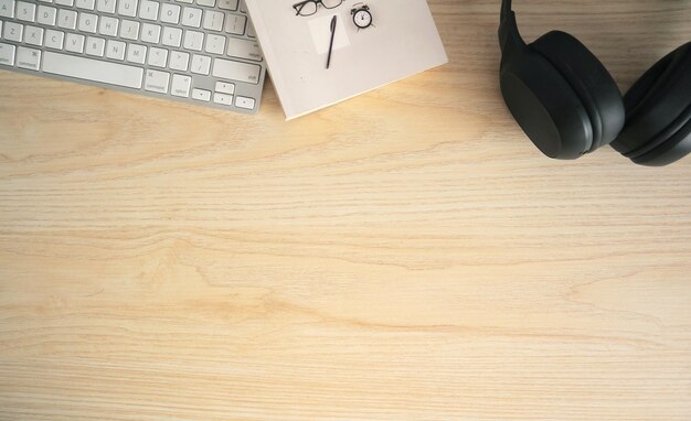 keyboard, book, and headphones on a table