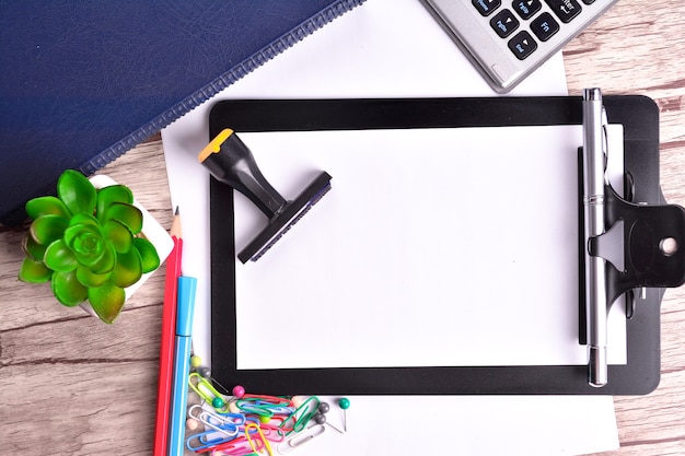 Keyboard, Clipboard with blank paper and office stationery on wooden table