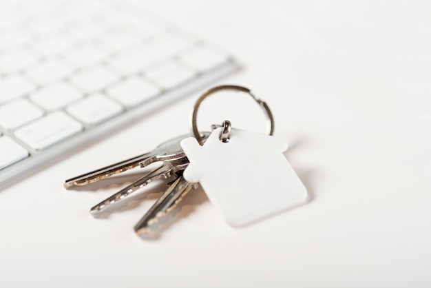 白い背景の上のキーボードと家の鍵