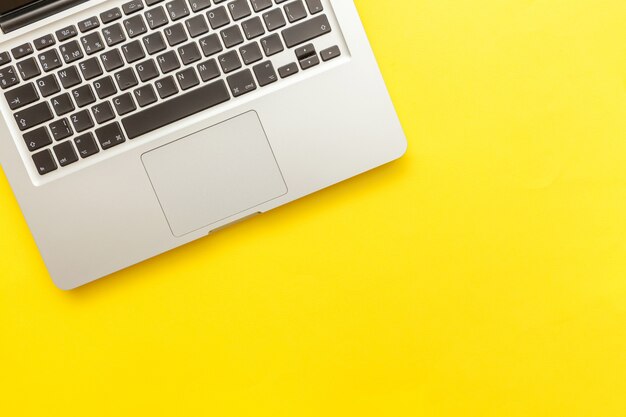 Keyboard laptop computer isolated on yellow desk 