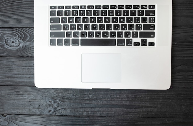 A keyboard of a laptop computer on a wooden table