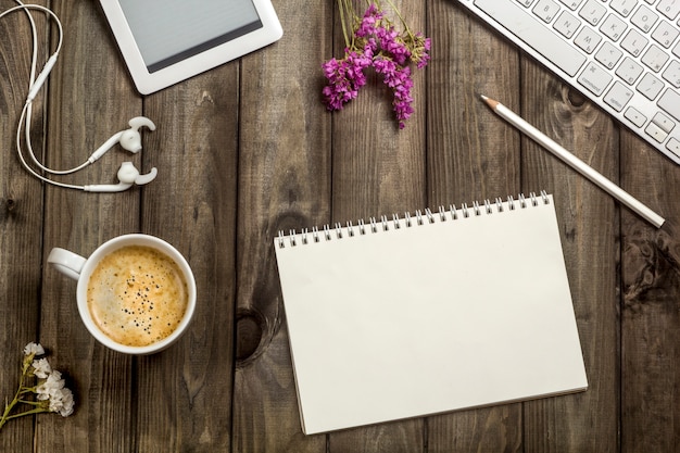 Keyboard, notebook, coffee cup, headphones working table