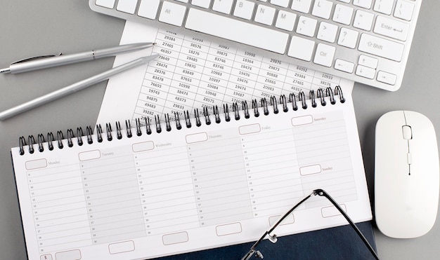 Keyboard and planner on grey background office workplace